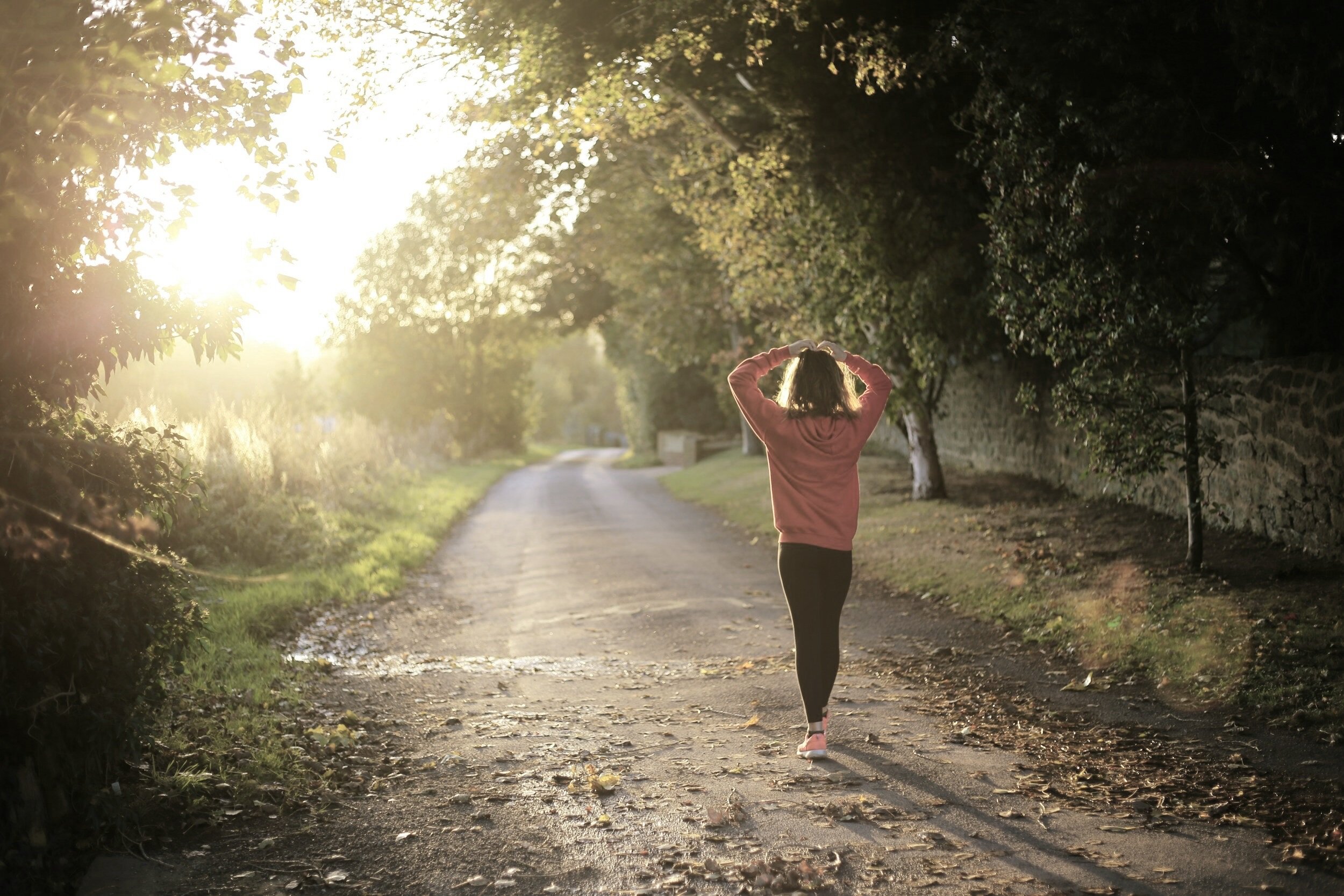 a women walking while making a heart symbol with hands